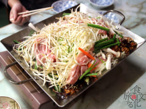 野菜と肉の山を崩し、全体を炒めていく