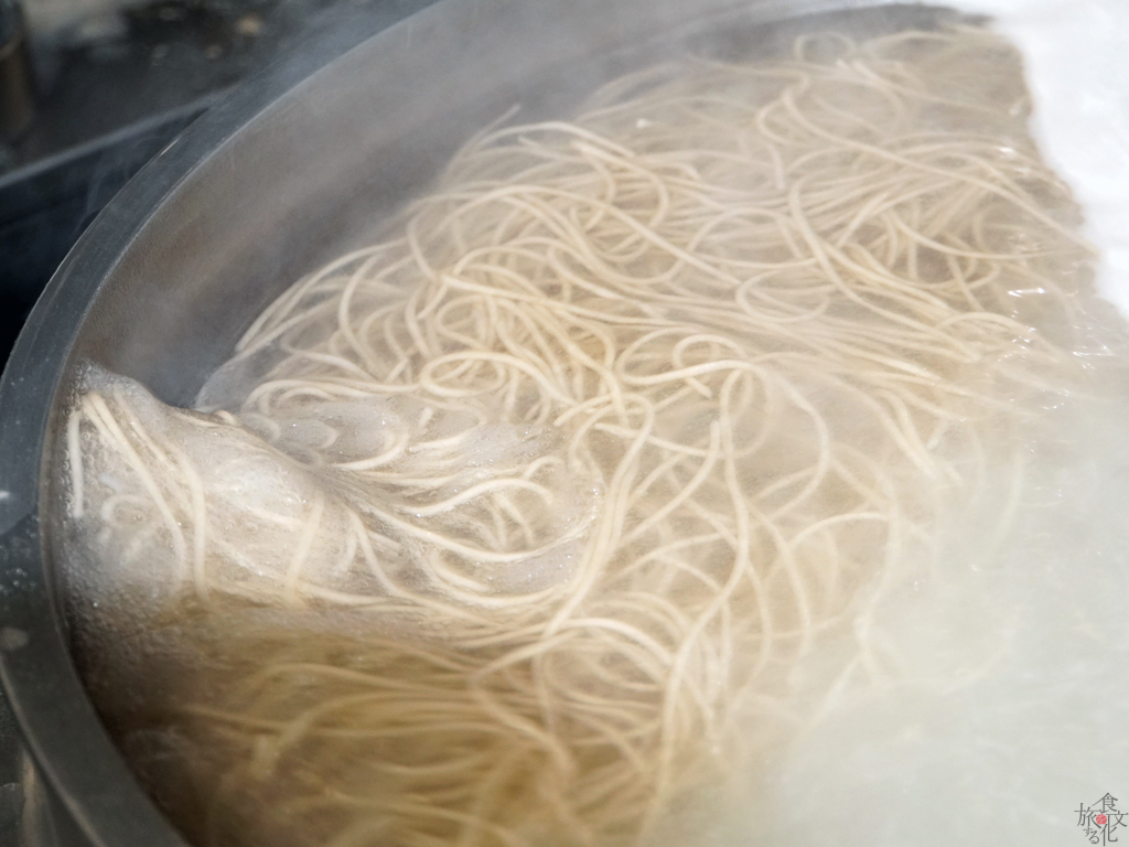 大釜でそばを茹でる